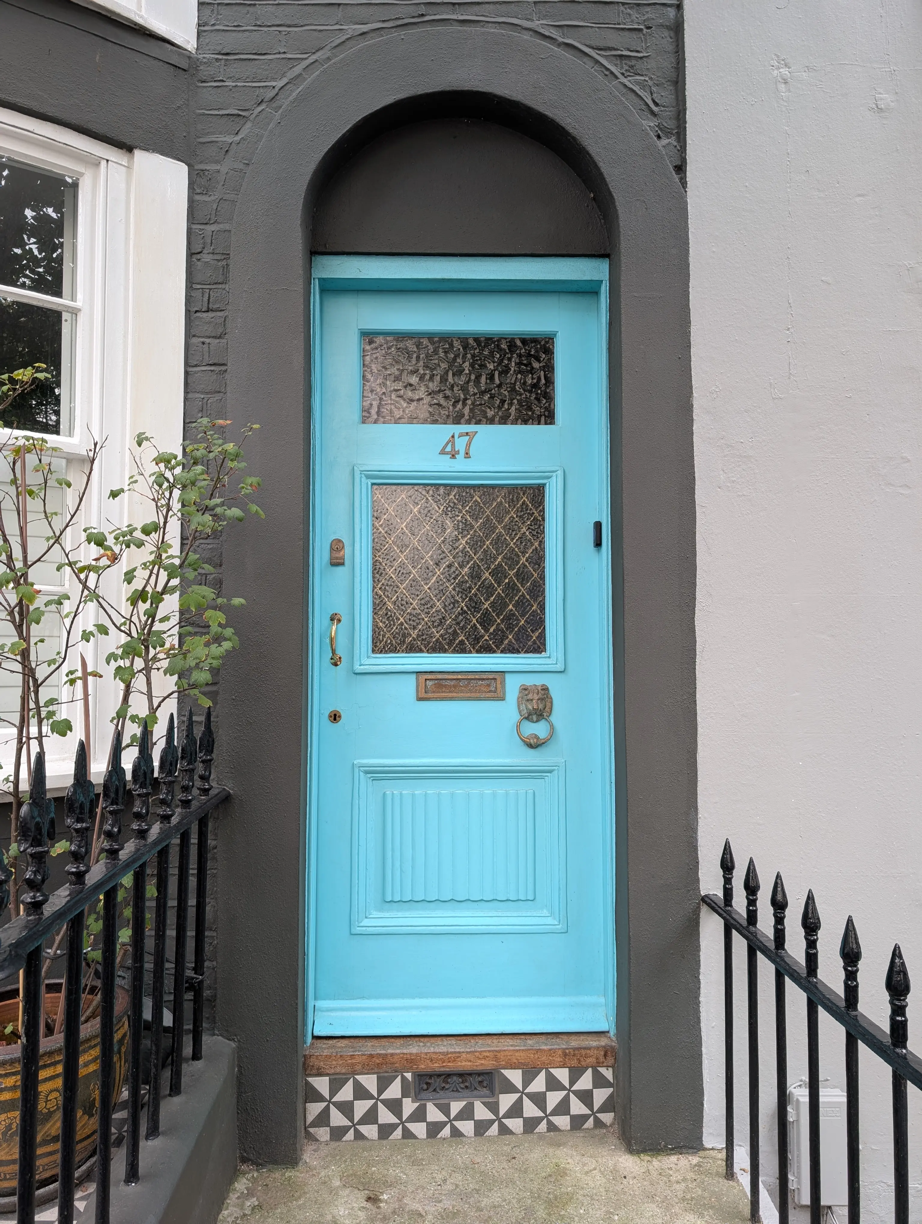 blue door with ornate lion knocker and tiling