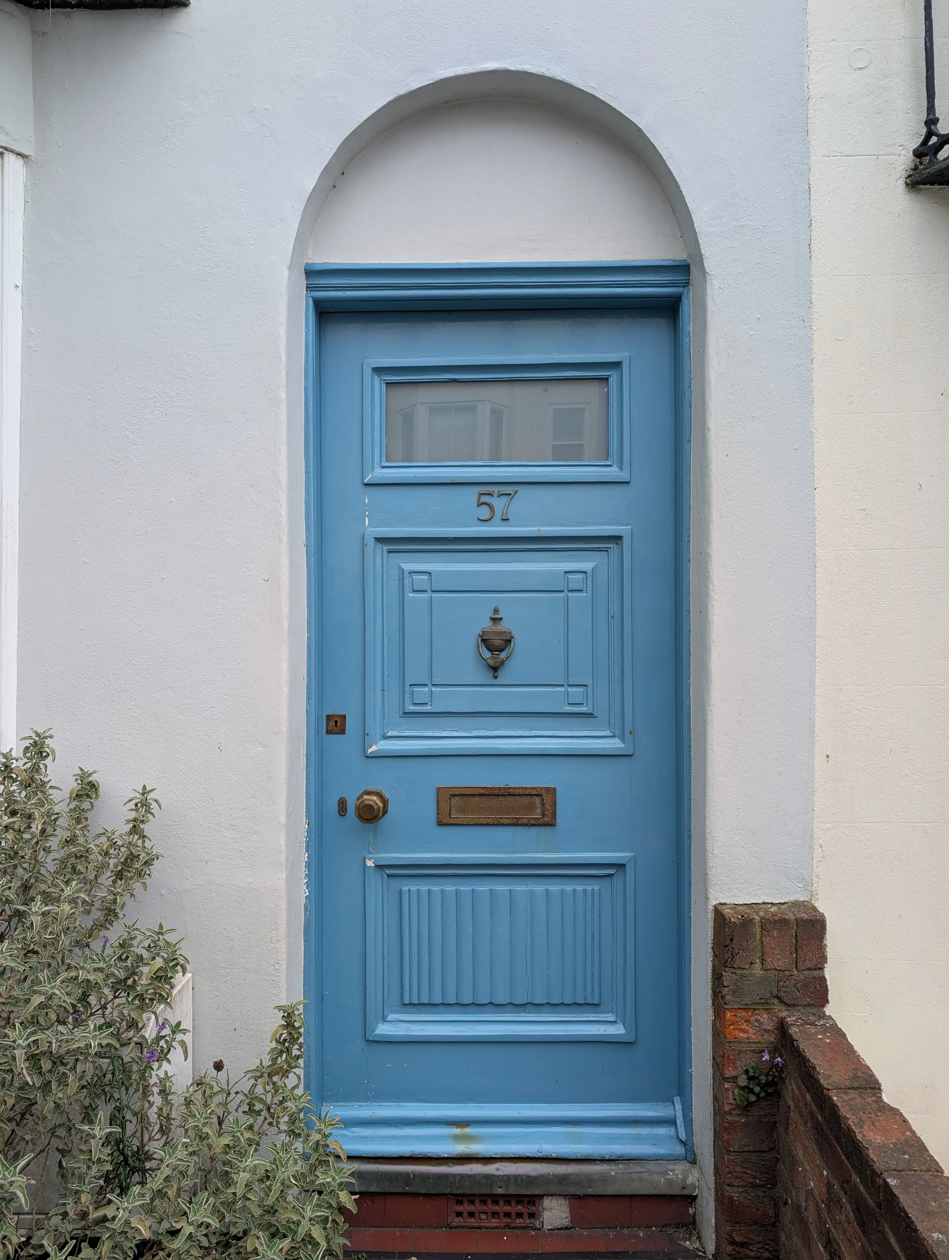 blue door with ornate styling on simple white building