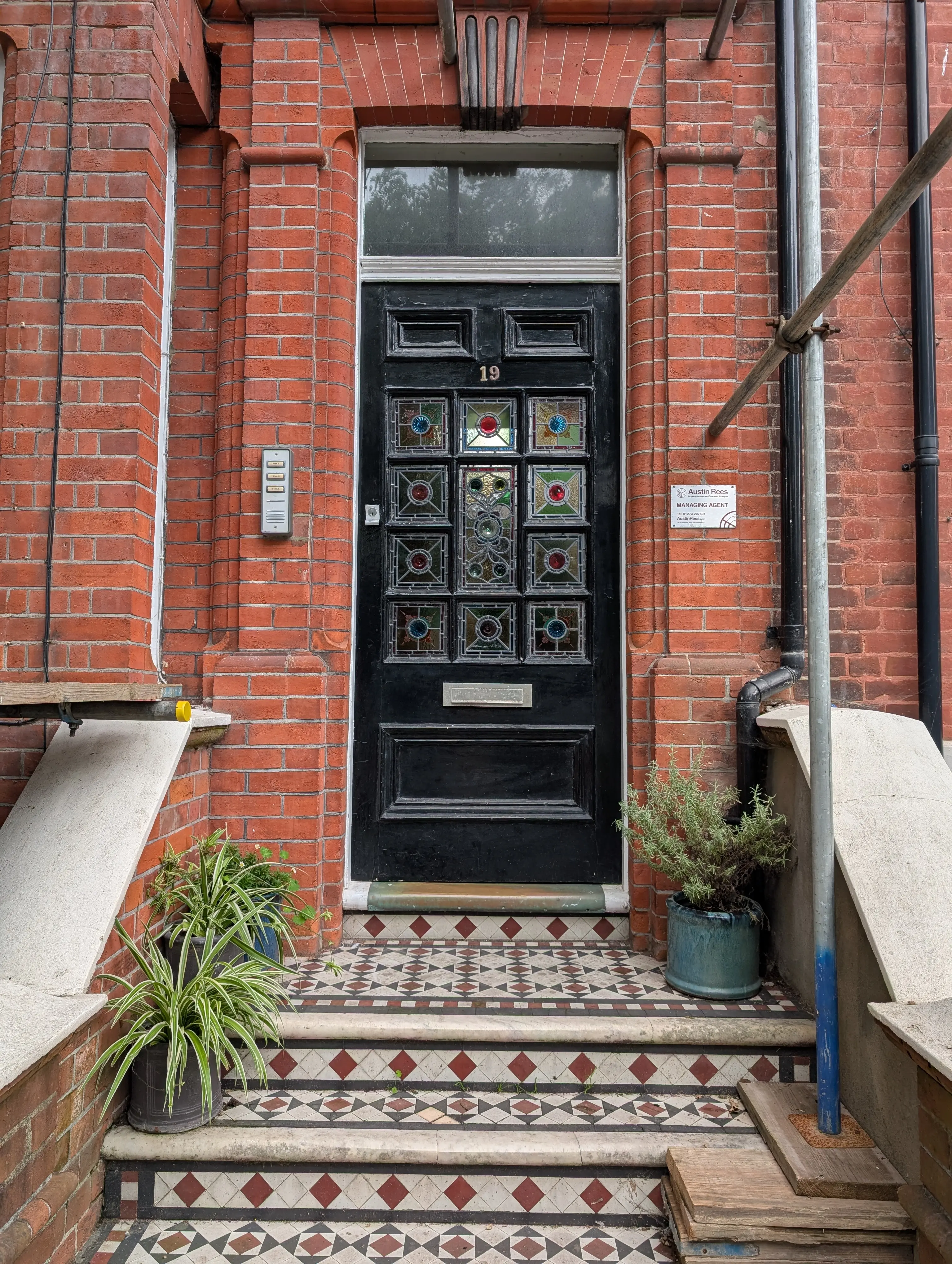 black door on red brick building with ornate glasswork