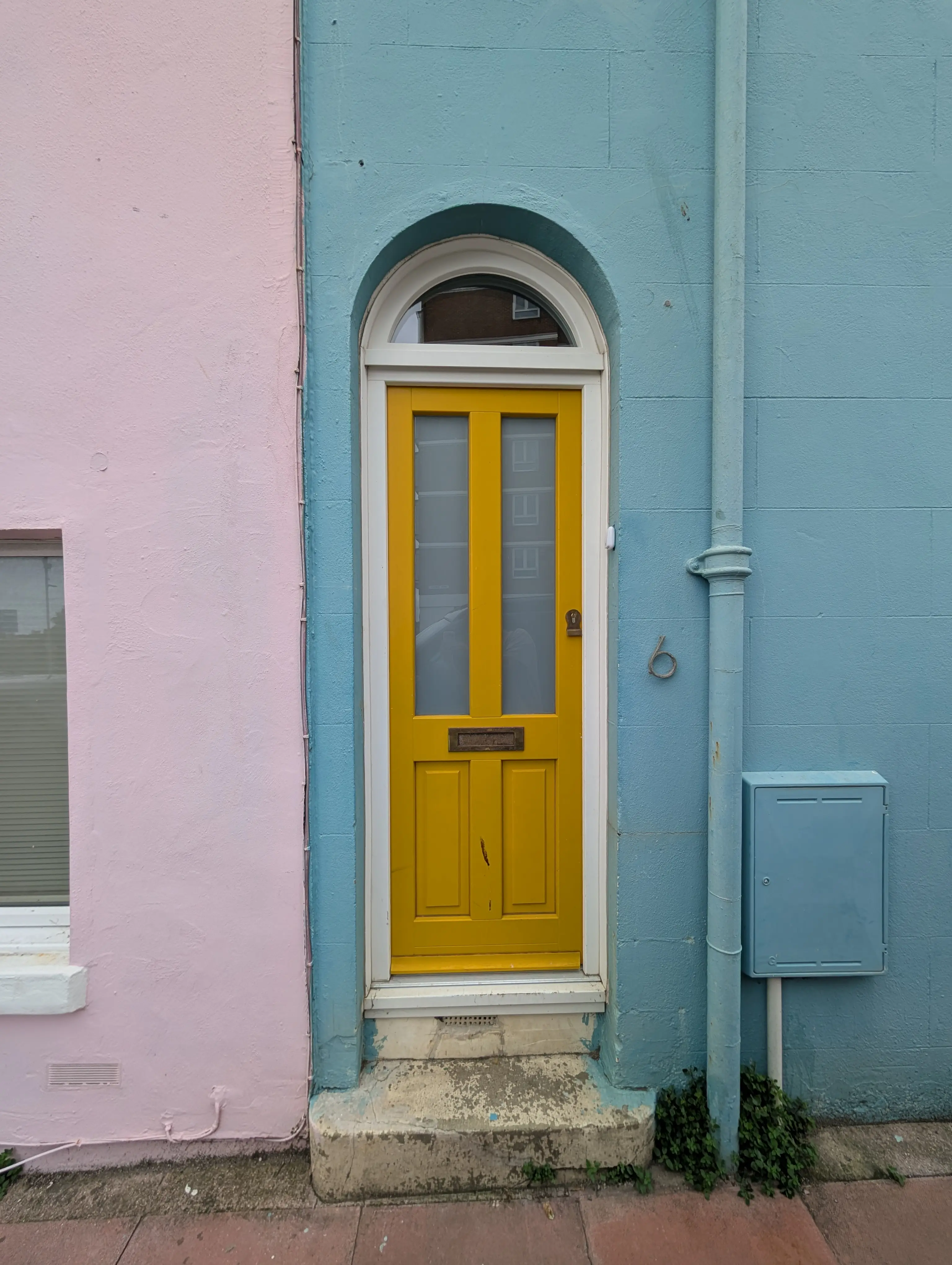 yellow door with white frame on a blue wall