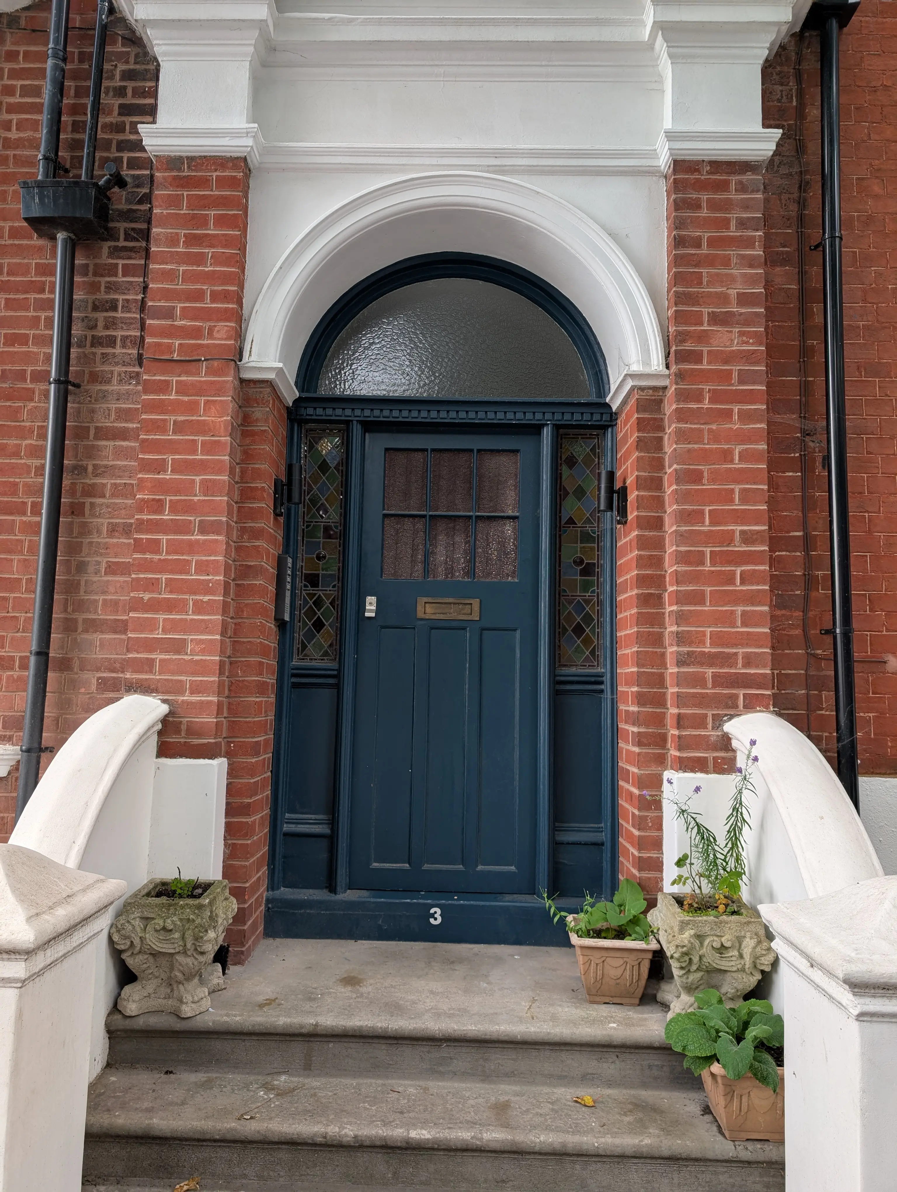 dark blue door with contrasting numbering on step below