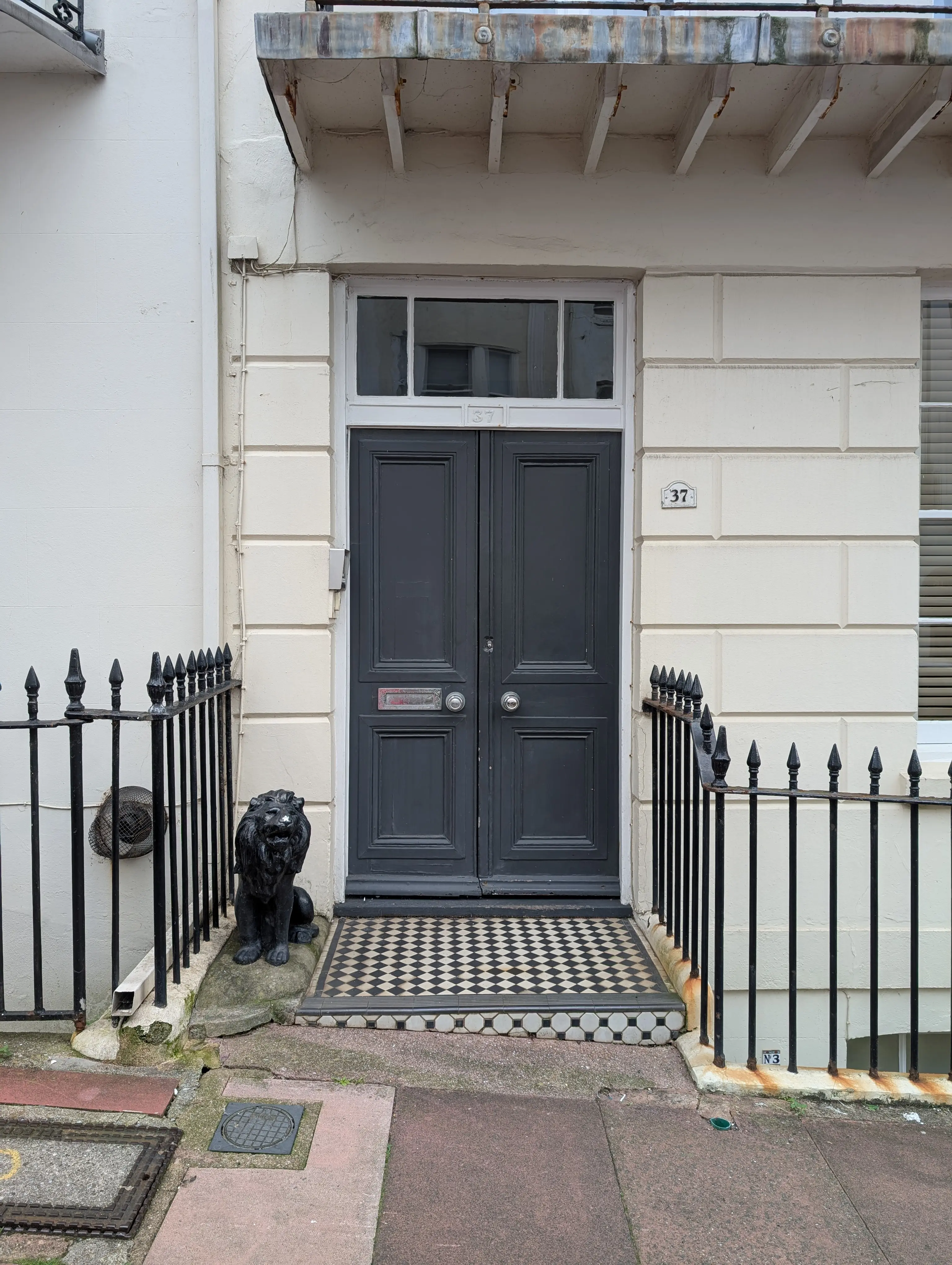 gray double doors and ornate lion statue