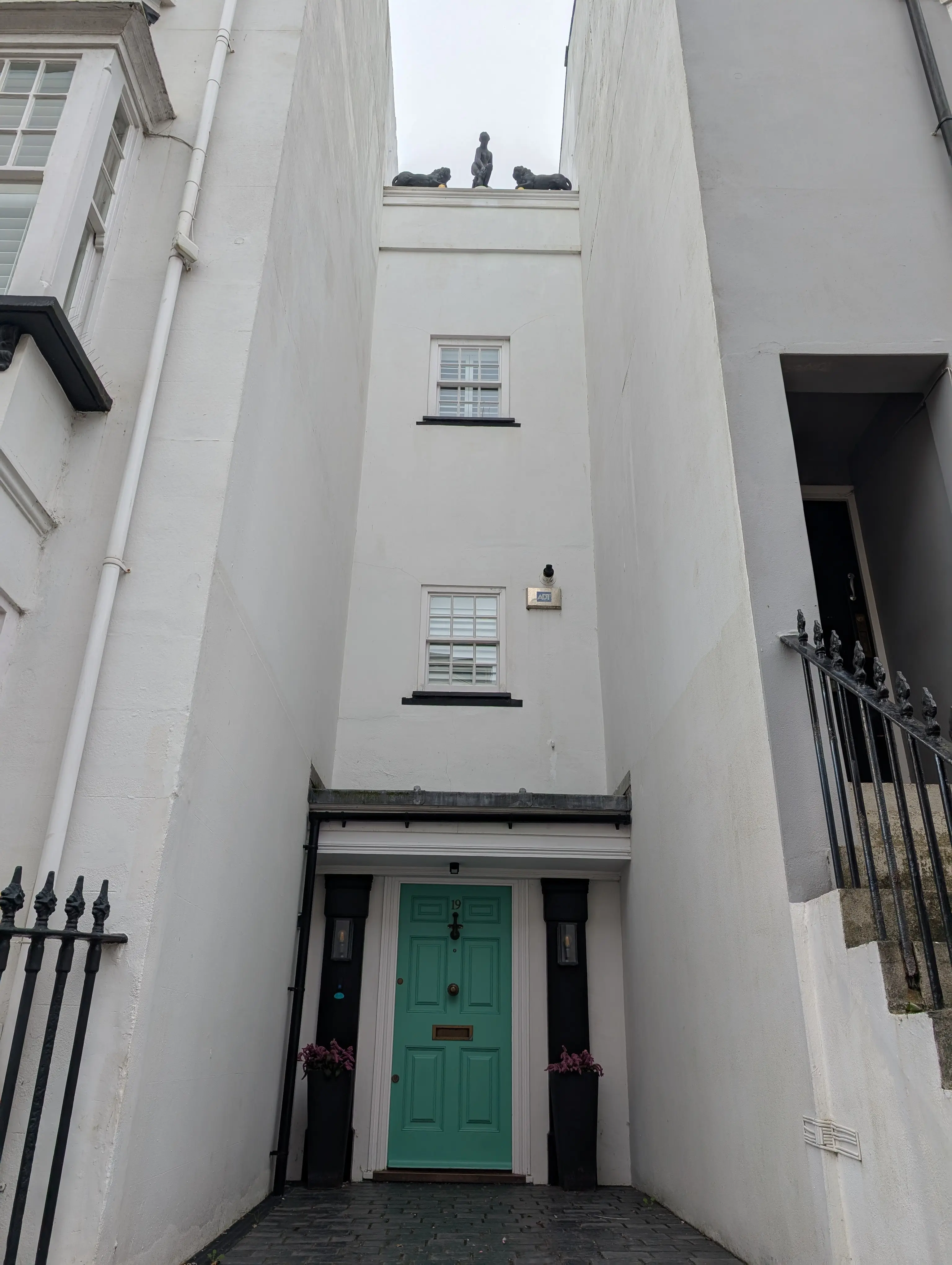 green door with ornate statues on roof