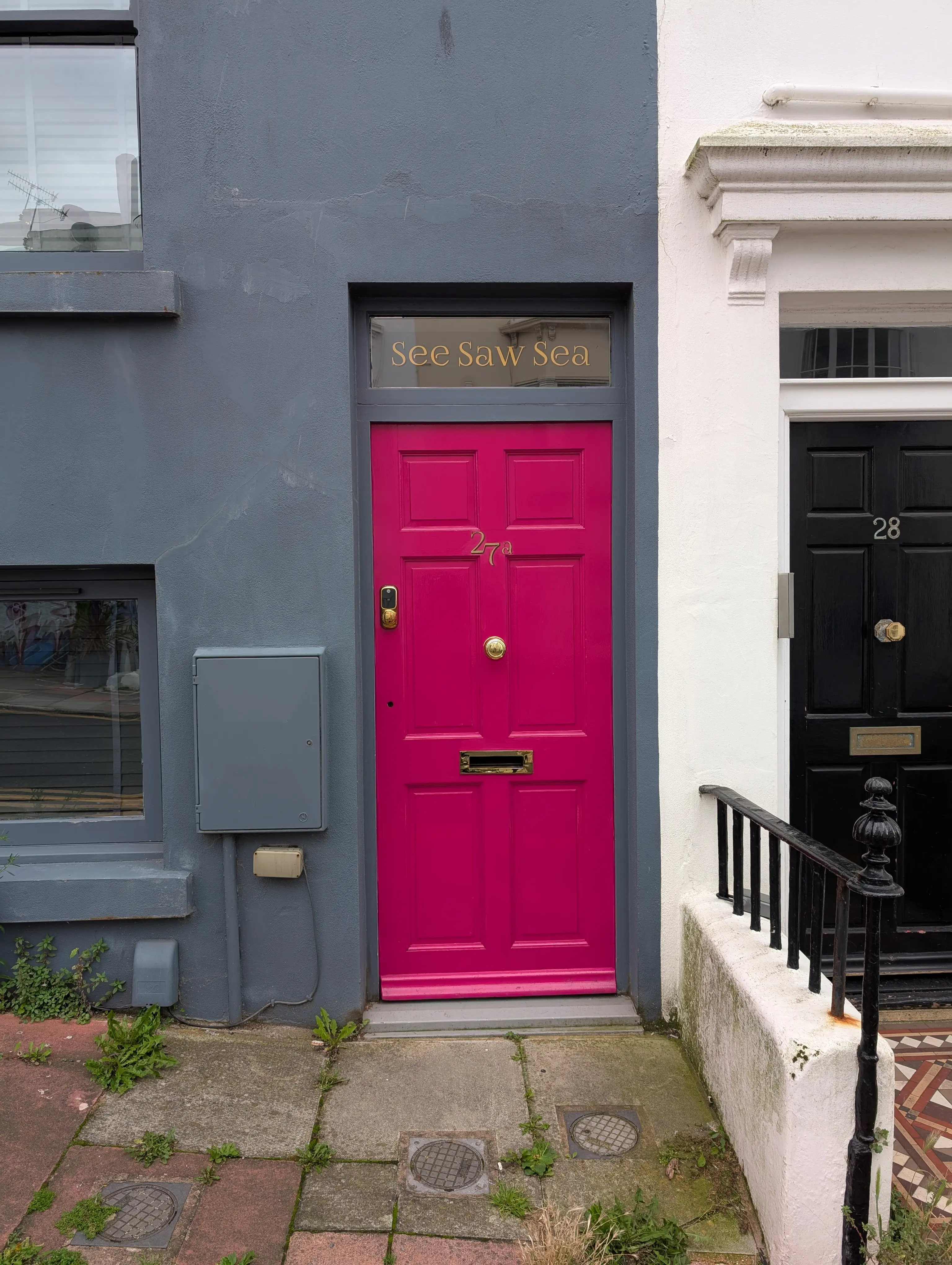 bright pink door with gold lettering above - see saw sea