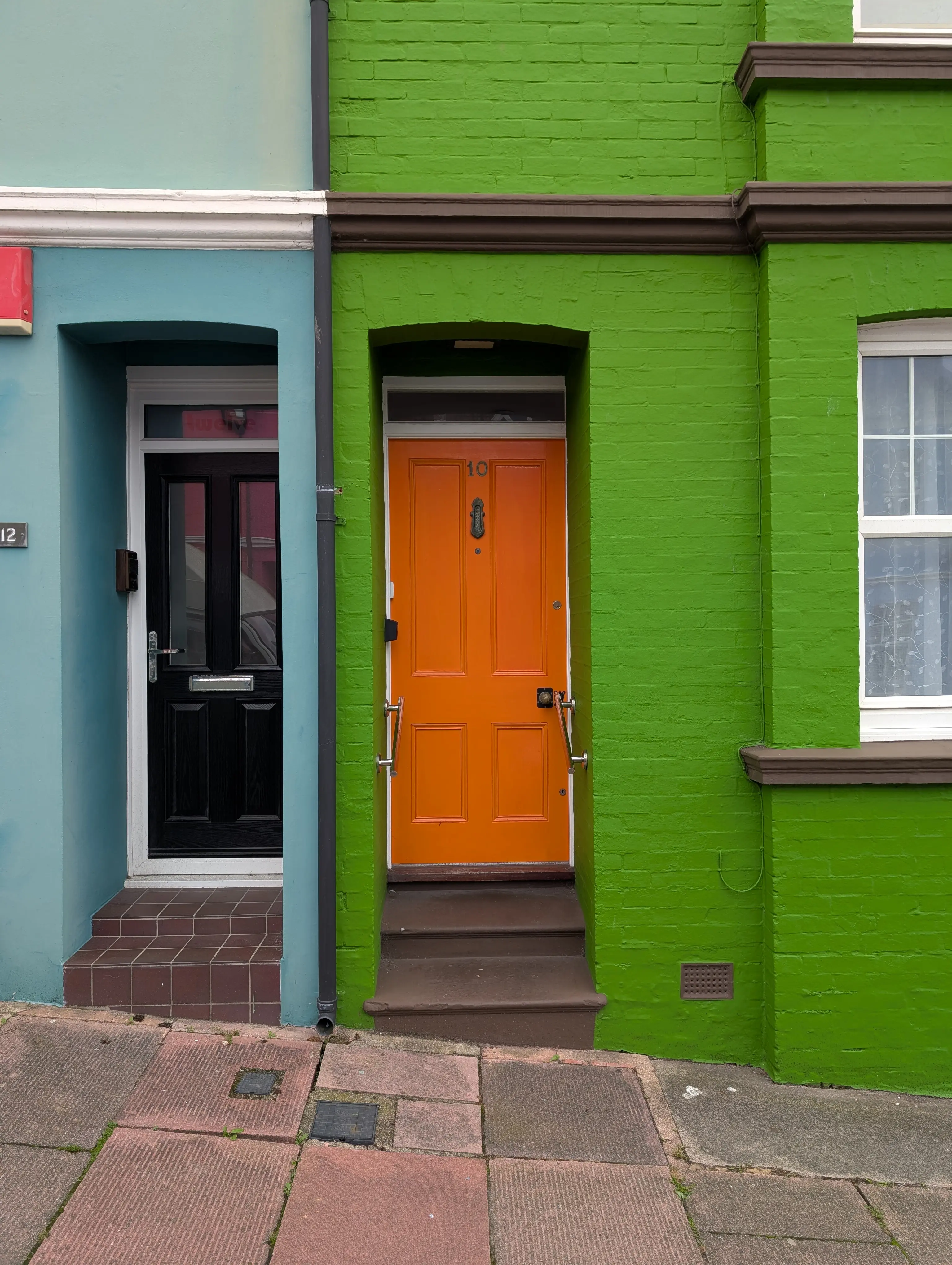 bright orange door on bright green building