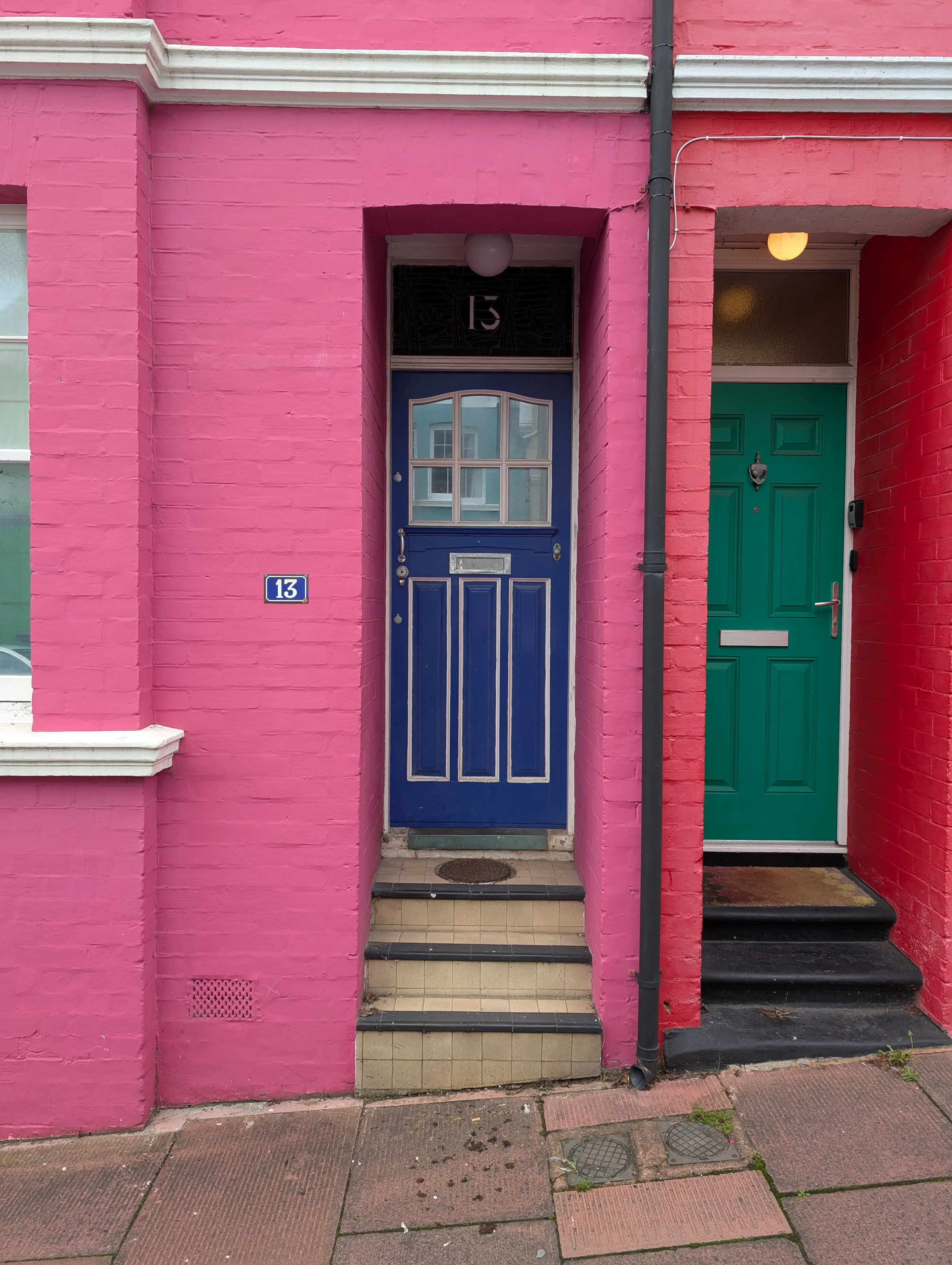 blue door with white stroke on pink building