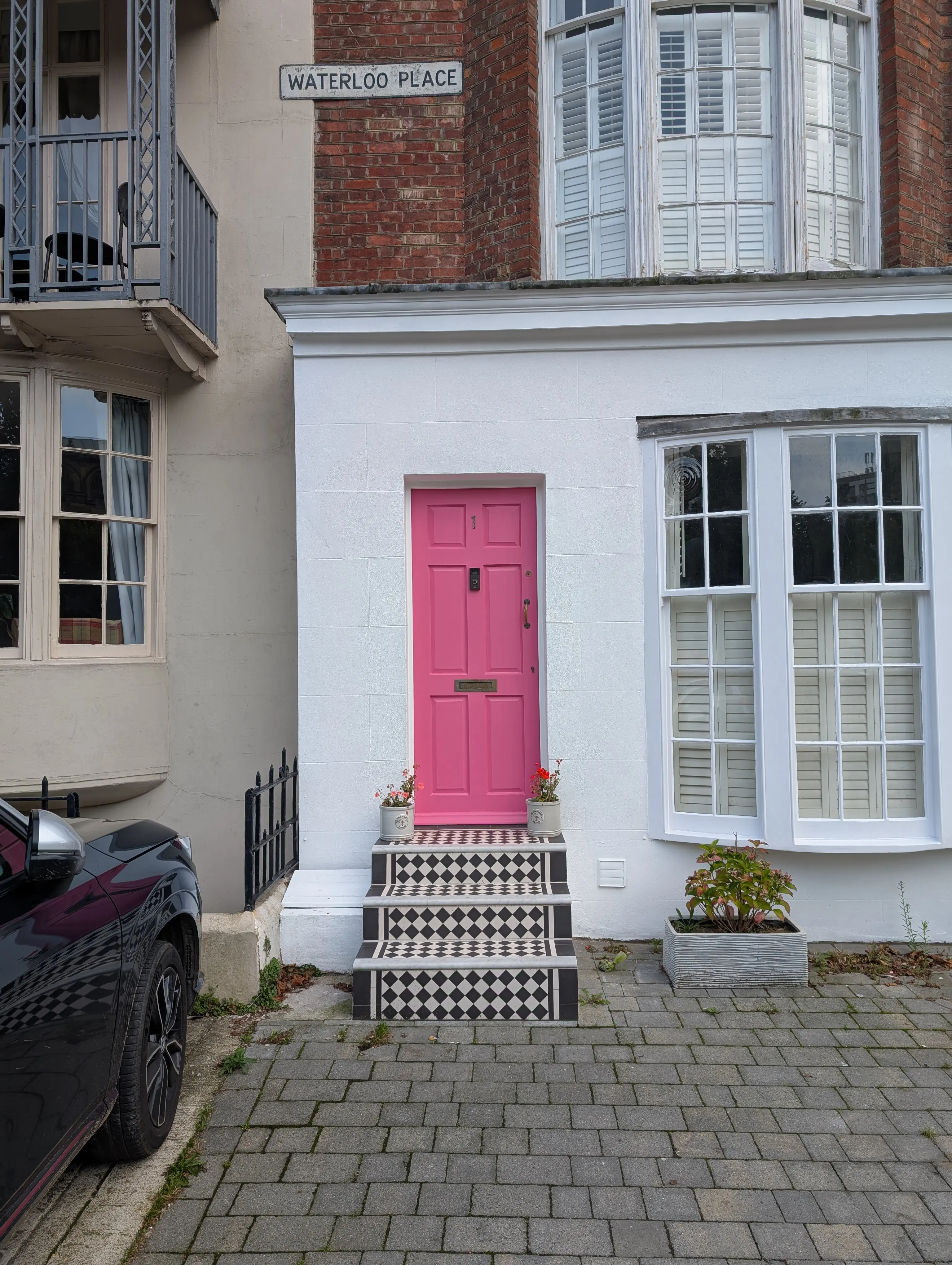 pink door on white building with ornate tiling