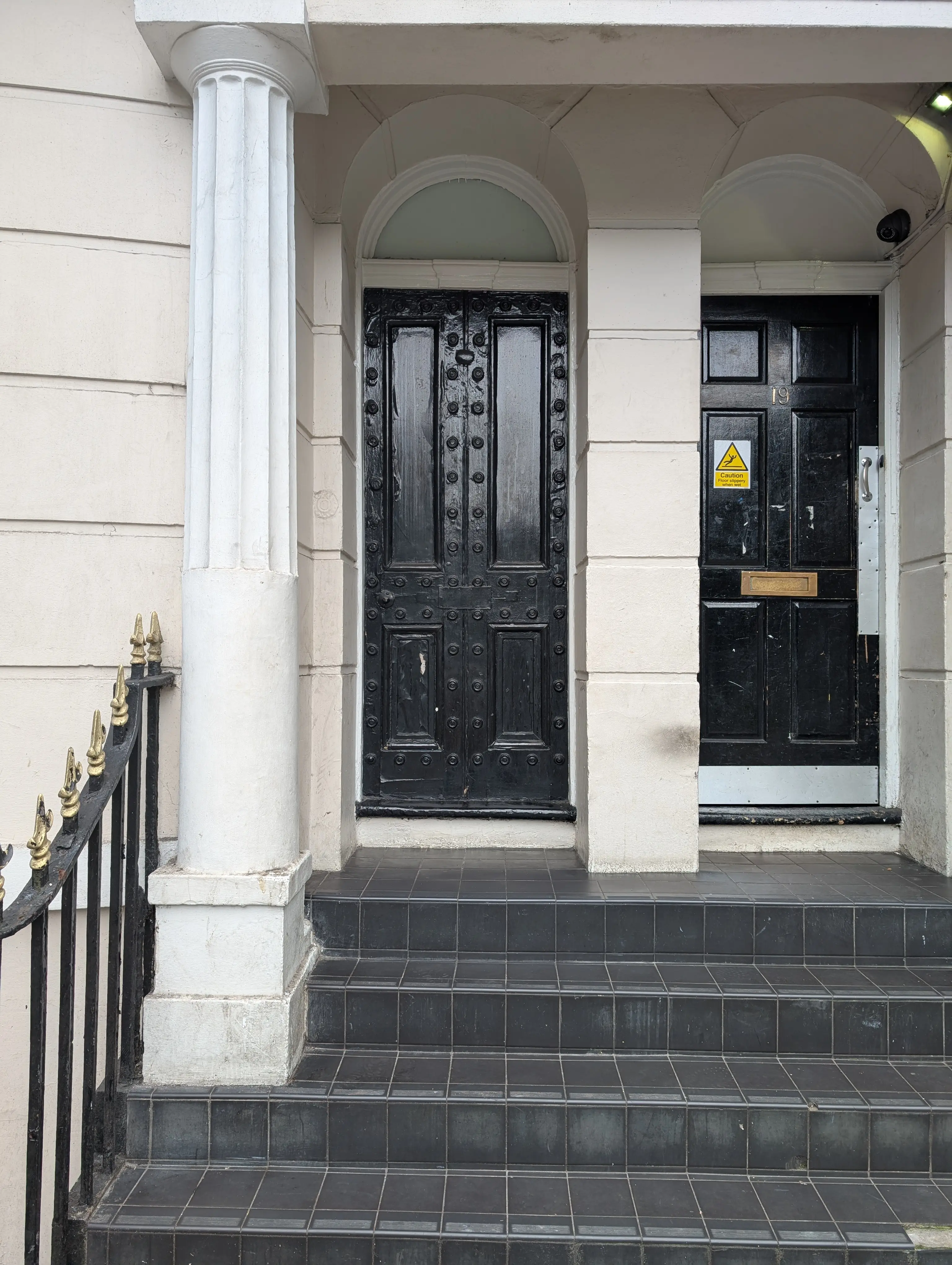 ornate black door with styled rivets around border