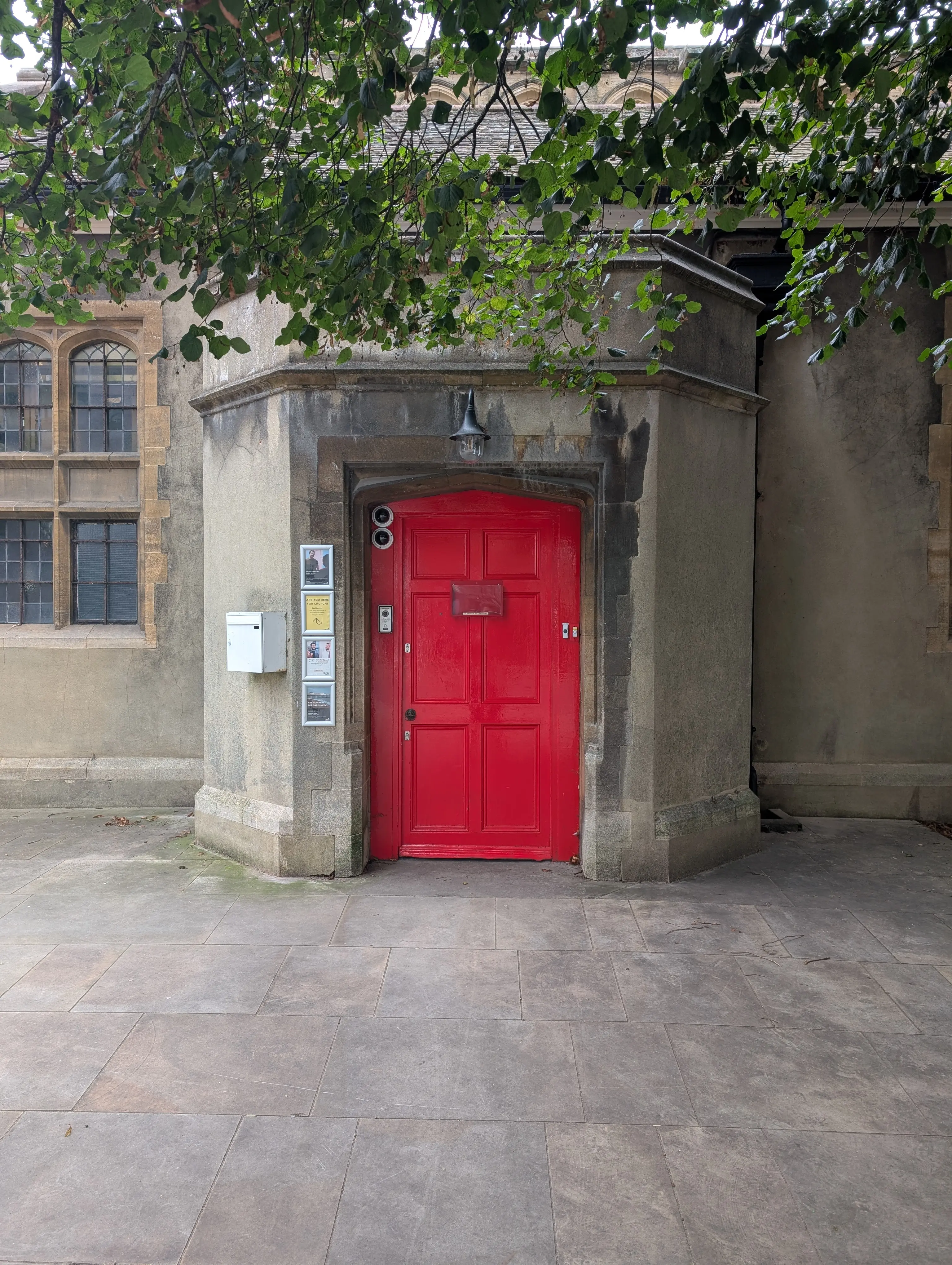 stout red church door surrounded by cameras, bells and buzzers