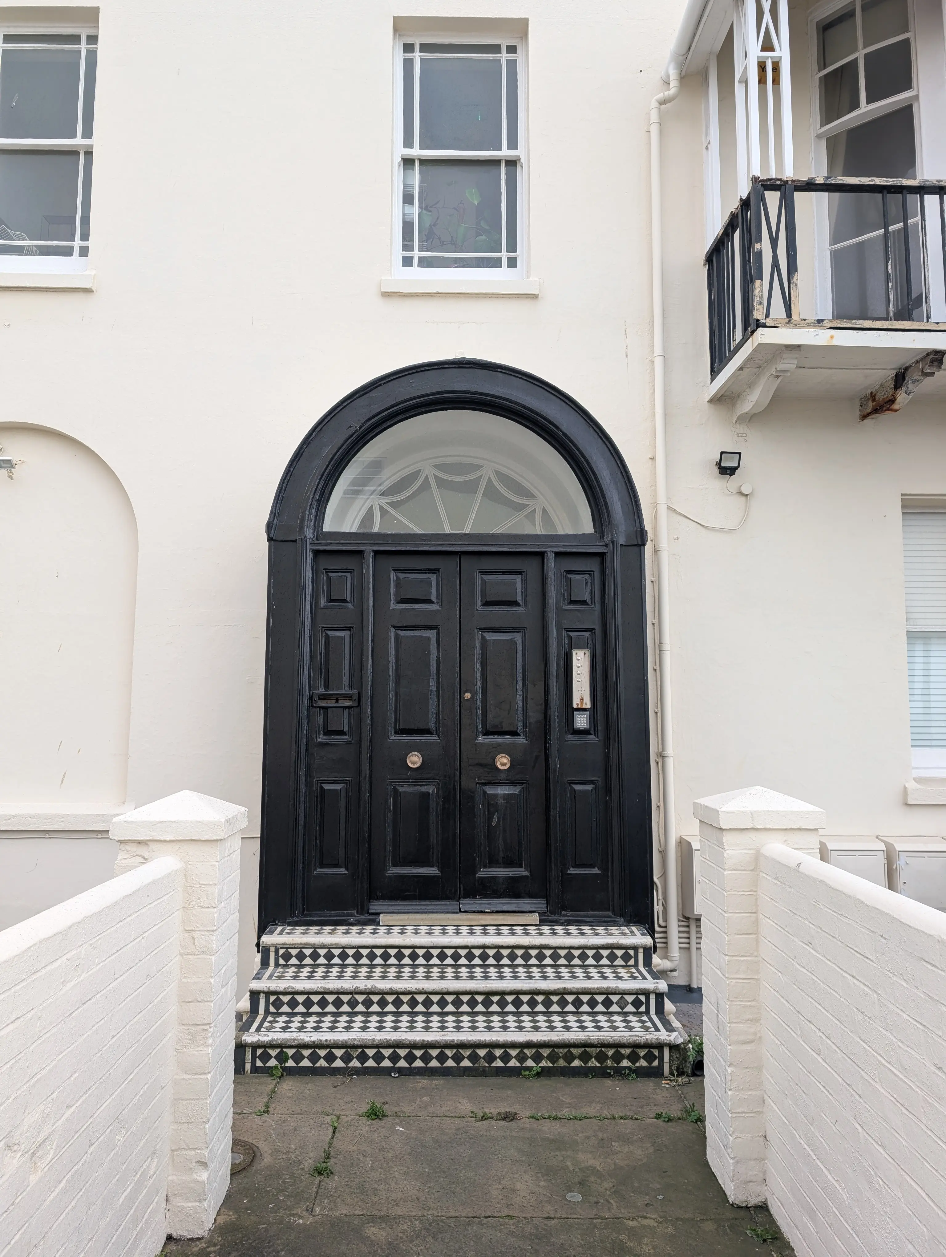 large double black doors, with a semi circular glass window above