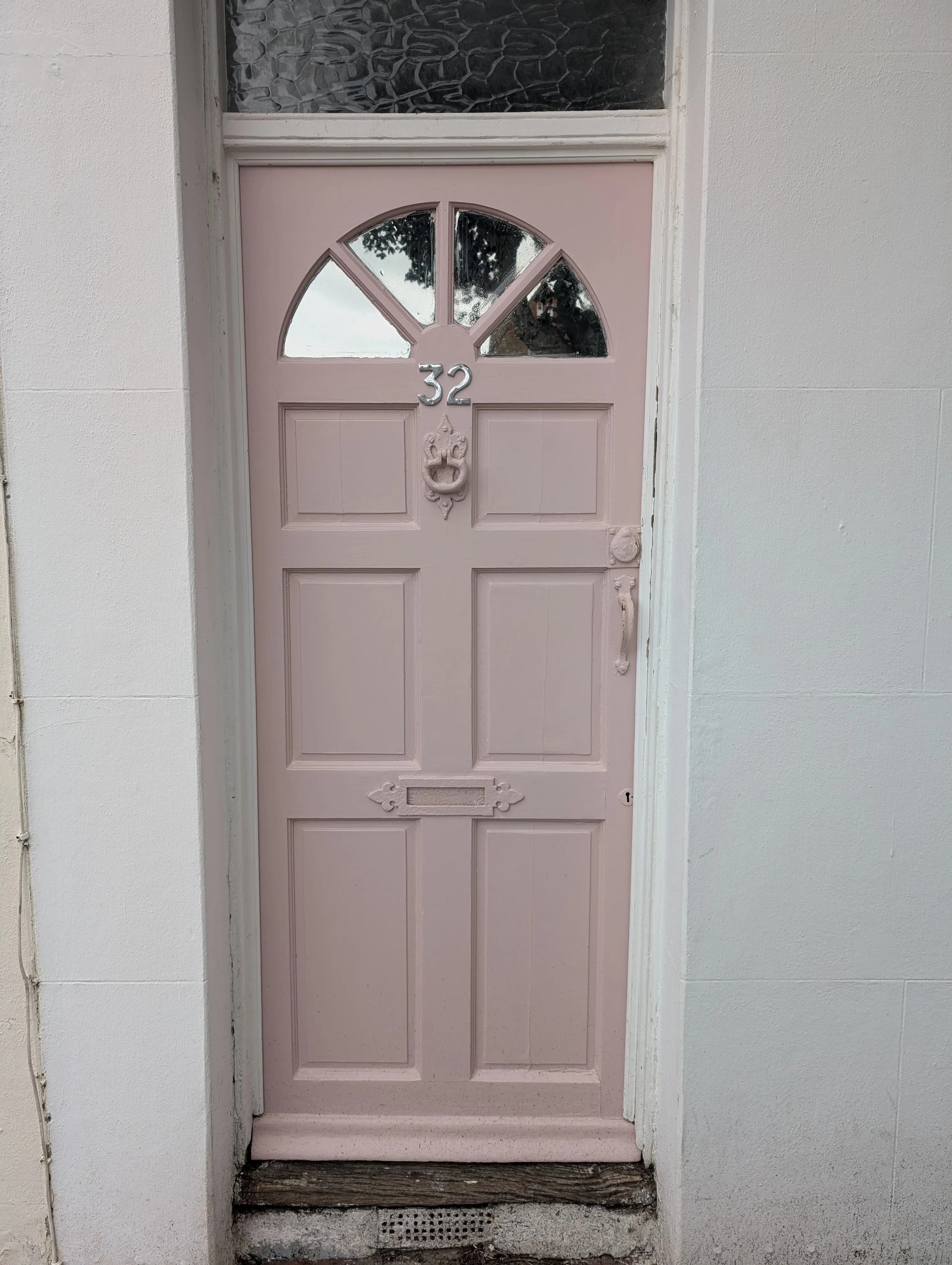 powder pink door with white frame and gray wall